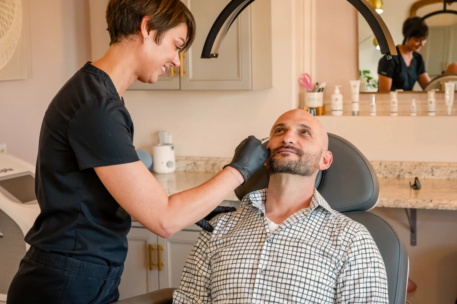 A practitioner administers an injectable treatment to a patient.